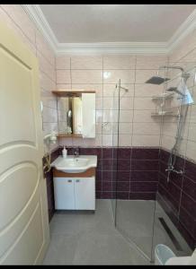a bathroom with a glass shower and a sink at Arzu otel apart in Datca