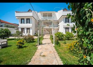 a white house with a garden in front of it at Arzu otel apart in Datca
