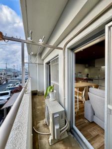 a balcony with a television and a kitchen with a table at Kame Ame House in Kameoka