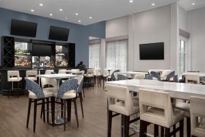 a restaurant with tables and chairs and a bar at Embassy Suites by Hilton Birmingham Hoover in Birmingham