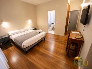 ein Schlafzimmer mit Bett, Tisch und Fernseher in der Unterkunft Budget Hotel Central in Osorno