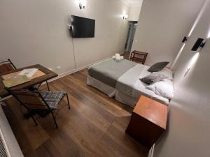 ein Schlafzimmer mit Bett, Schreibtisch und Fernseher in der Unterkunft Budget Hotel Central in Osorno + 21 Fotos