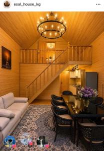 a living room with a couch and a table and a staircase at Esal house in Chon-Sary-Oy