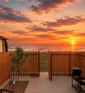 a sunset on the beach with a wooden fence at Esal house in Chon-Sary-Oy