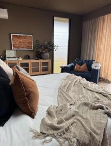 a bedroom with a bed with a blanket on it at Wilderluxe Lake Keepit in Keepit