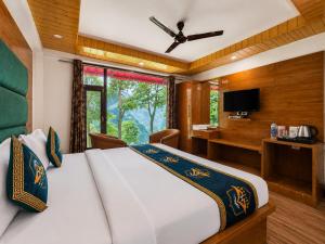 a bedroom with a bed and a desk and a television at Kavin Highland - The Mall Dalhousie in Dalhousie