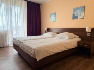 a bedroom with a large bed with two pillows at Motel Pieprzyk in Kołobrzeg