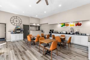 a dining room with tables and chairs and a kitchen at Quality Inn Oskaloosa in Oskaloosa
