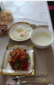 a table with two plates of food on a table at Azamat Yurt Camp in Song-Kul