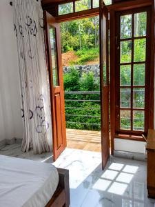 a bedroom with a door open to a patio at Silver Tips Villa in Ella