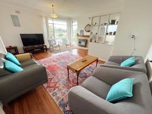 a living room with two couches and a television at Conns Cottage - Bring your own linen in South West Rocks