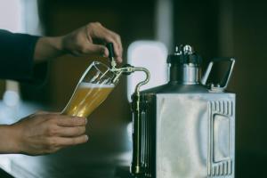 a person drinking a glass of beer next to a juicer at 暇家 kaya in Yosano