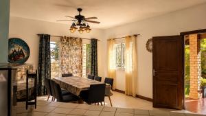 a dining room with a table and a ceiling fan at Villa de standing à Ivato in Antananarivo