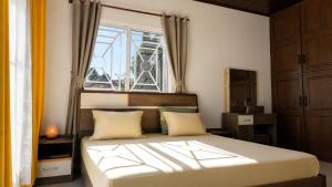 a bedroom with a large bed with a window at Villa de standing à Ivato in Antananarivo