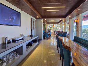 a restaurant with a long bar with blue chairs at Kavin Highland - The Mall Dalhousie in Dalhousie