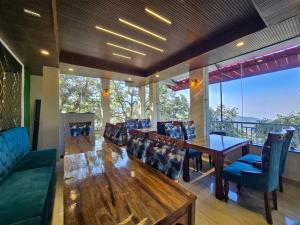 a dining room with a long table and chairs at Kavin Highland - The Mall Dalhousie in Dalhousie