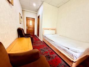 a room with a bed and a couch and a chair at City Hostel & Tours in Ulaanbaatar