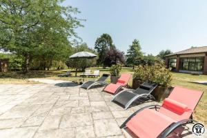 a group of chairs and an umbrella on a patio at En sales in Saint-Jean-Lherm