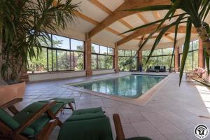 a swimming pool in a house with a conservatory at En sales in Saint-Jean-Lherm