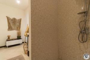 a bathroom with a shower with a tiled wall at En sales in Saint-Jean-Lherm +30 photos