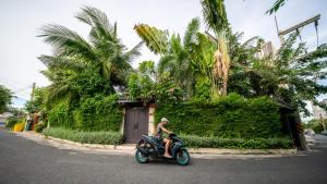 a person riding a motorcycle down the street at Pattaya Bungalow III, Totally Private Pool in Pattaya South