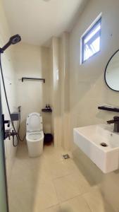 a white bathroom with a sink and a toilet at Ann Arbor Hotel in Ho Chi Minh City