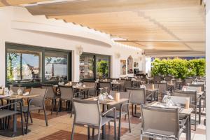 a restaurant with tables and chairs and windows at Hotel Diana in Tossa de Mar