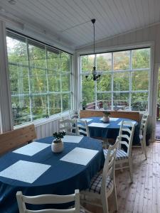 a dining room with blue tables and chairs and windows at Lindum Hotell in Suldalsosen