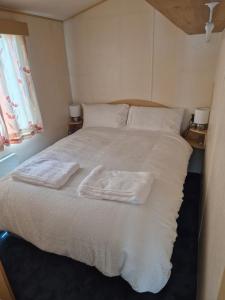 a bedroom with a bed with two towels on it at Cabin Sleeps 6 with access outdoor Pool in Sandown