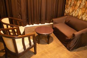 a living room with a couch and a chair and a table at Aira Suites in Bangalore +35 photos