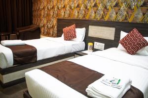 a hotel room with two beds and two chairs at Aira Suites in Bangalore