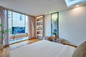 a bedroom with a bed and a large window at Cactusland Boutique Hotel in Ho Chi Minh City +25 photos