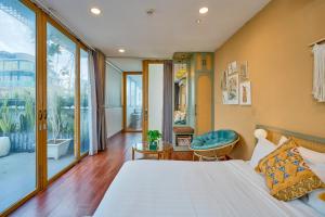 a bedroom with a bed and a large window at Cactusland Boutique Hotel in Ho Chi Minh City