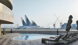 a pool with lounge chairs and a view of the harbor at Saadiyat Serenity 1BR apartment with Beach access in Abu Dhabi