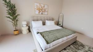 a bedroom with a large bed with white walls at Saadiyat Serenity 1BR apartment with Beach access in Abu Dhabi +33 photos