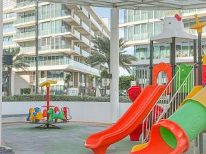 a playground with a slide and a slideintend at Saadiyat Serenity 1BR apartment with Beach access in Abu Dhabi