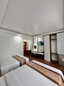 a hotel room with two beds and a television at SunWay hotel in Cat Ba