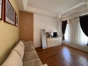 a living room with a couch and a tv at Sanghiang Homestay in Batukaras