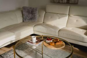 a living room with a couch and a coffee table with a tray of food at 304 - Chic Minimalist Condo - River & Serenity in Baie-Saint-Paul