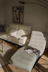 a living room with a white couch and a table at 304 - Chic Minimalist Condo - River & Serenity in Baie-Saint-Paul +59 photos