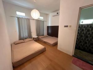 a bedroom with two beds and a window at Sanghiang Homestay in Batukaras