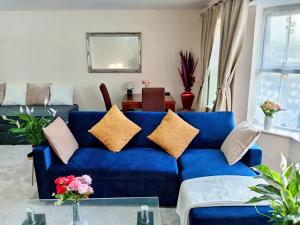 a blue couch with pillows in a living room at 2 Bedrooms Flat in Surrey, 30 min to London in Woking