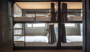 two bunk beds in a room with a window at Westory Design Poshtel in Kanchanaburi City