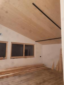 an empty room with wooden floors and windows at Panoramablick Kaunergrat Homes in Kaunerberg