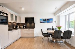 a kitchen and dining room with a table and chairs at Ferienwohnung Aquamarin im Haus Arkona Prora in Binz +23 photos