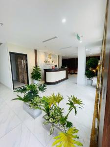 a lobby with potted plants and a reception desk at Sky Love Hotel - Trâu Qùy in Thạch Cầu