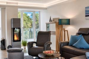 a living room with a couch and a fireplace at Ferienwohnung Aquamarin im Haus Arkona Prora in Binz