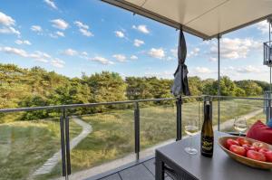 a table with wine glasses and a bowl of fruit on a balcony at Ferienwohnung Aquamarin im Haus Arkona Prora in Binz