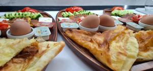 a table with two trays of food with eggs and pie at Hyka Stone House Shkoder in Shkodër