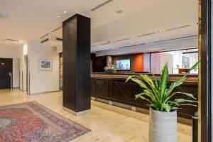 a lobby with a counter with a potted plant at Hotel IMLAUER & Bräu in Salzburg